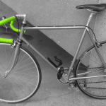 A Silver bicycle on a concrete background, only the neon green bar tape stands out.