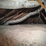 A small attic space with rafters and ductwork visible over an undulating landscape of insulation.